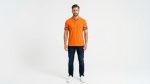 Man wearing a premium men's vibrant orange polo shirt with bold black and white striped sleeve cuffs