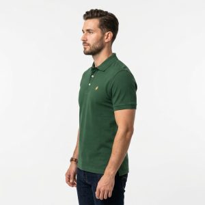 Man wearing a premium men's forest green polo shirt featuring a small embroidered tree logo on the chest