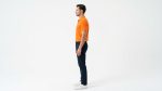 Man wearing a premium men's vibrant orange polo shirt with bold black and white striped sleeve cuffs