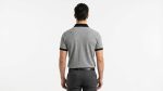 Man wearing a premium men's heather grey polo shirt featuring a contrast black chest pocket and black collar
