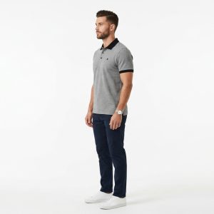Man wearing a premium men's heather grey polo shirt featuring a contrast black chest pocket and black collar