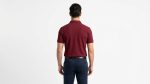 Man wearing a premium men's burgundy maroon polo shirt with a gold embroidered laurel wreath logo on the chest