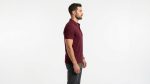Man wearing a premium men's burgundy maroon polo shirt with a gold embroidered laurel wreath logo on the chest