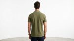 Man wearing a premium men's olive green polo shirt featuring a contrast chest pocket with a topographic map design and flap button closure