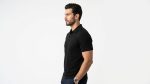 Man wearing a premium men's obsidian black polo shirt with a silver tipped collar and an embroidered A logo on the chest